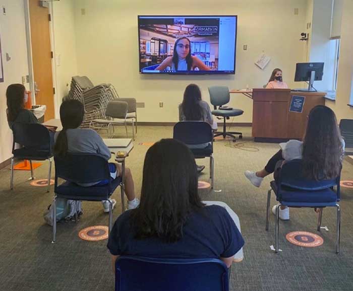 women are seated away from each other in a Zoom session