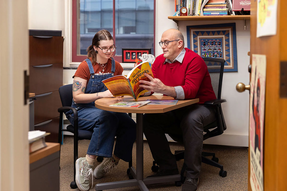 Professor George Theoharis reading a book to a student