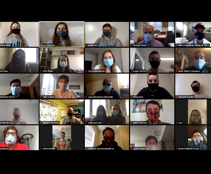 Multiple persons are in a Zoom session with masks on
