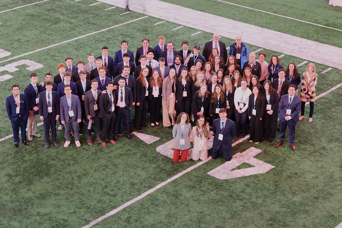 Group shot of Sport Management Club Members standing on football field inside the Dome