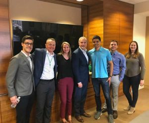 seven people pose in a conference room