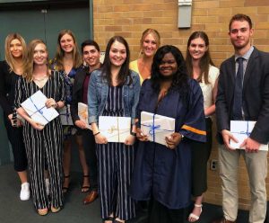 Students pose holding awards