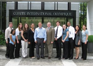 12 persons pose in front of the Comite International Olympique building