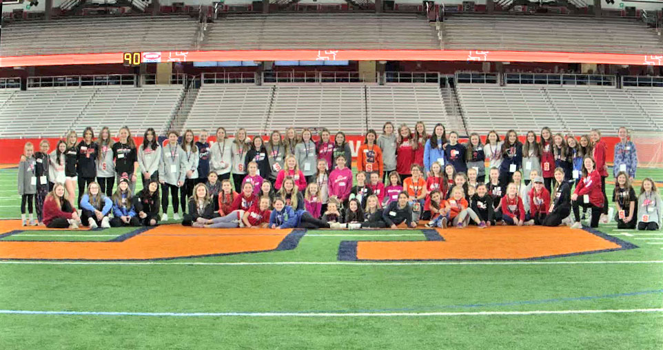 a large group of kids posed on a sport field