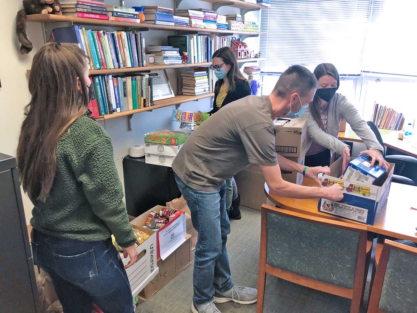 4 persons are organizing items in a room