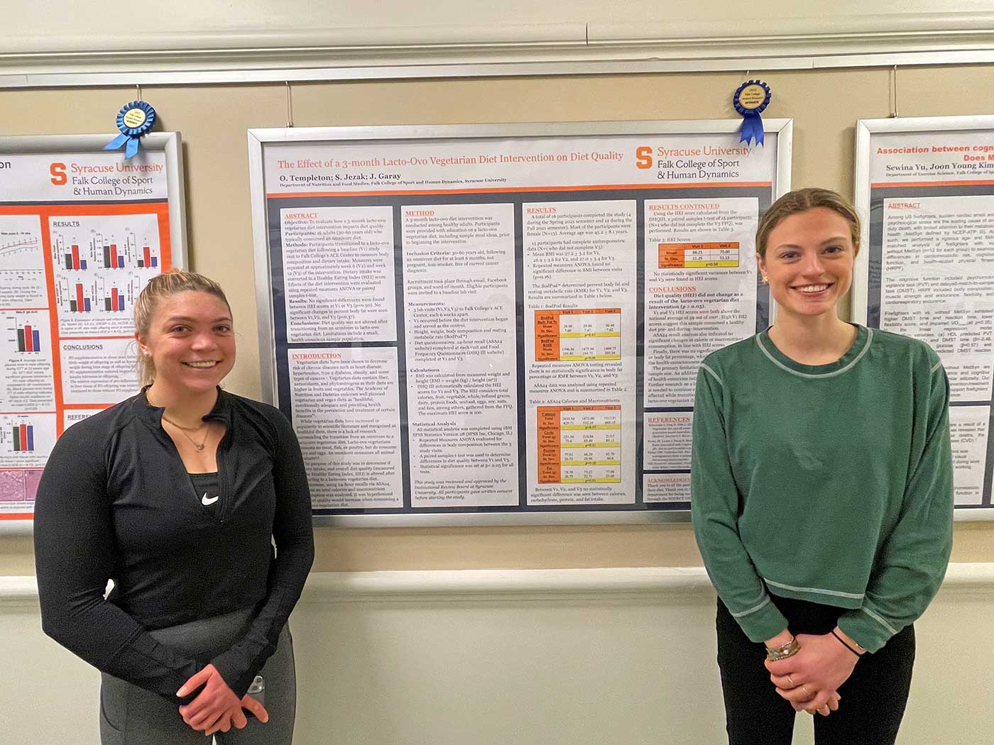 Two students pose next to their poster.