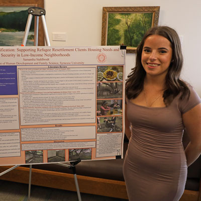 Samantha stands next to a research poster