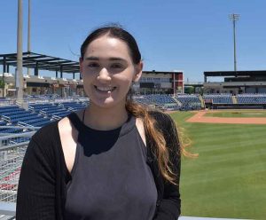 Shanthi stands in a baseball stadium