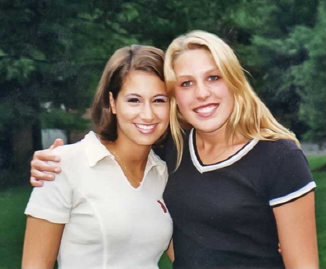 Two women are posed together outside