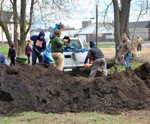 Students and Professor work on a pile of dirt