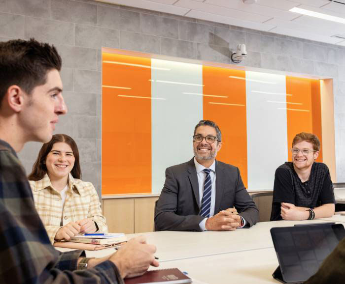 3 students and the dean sitting at a table