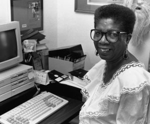 Wynetta Devore sits at a desk with a computer