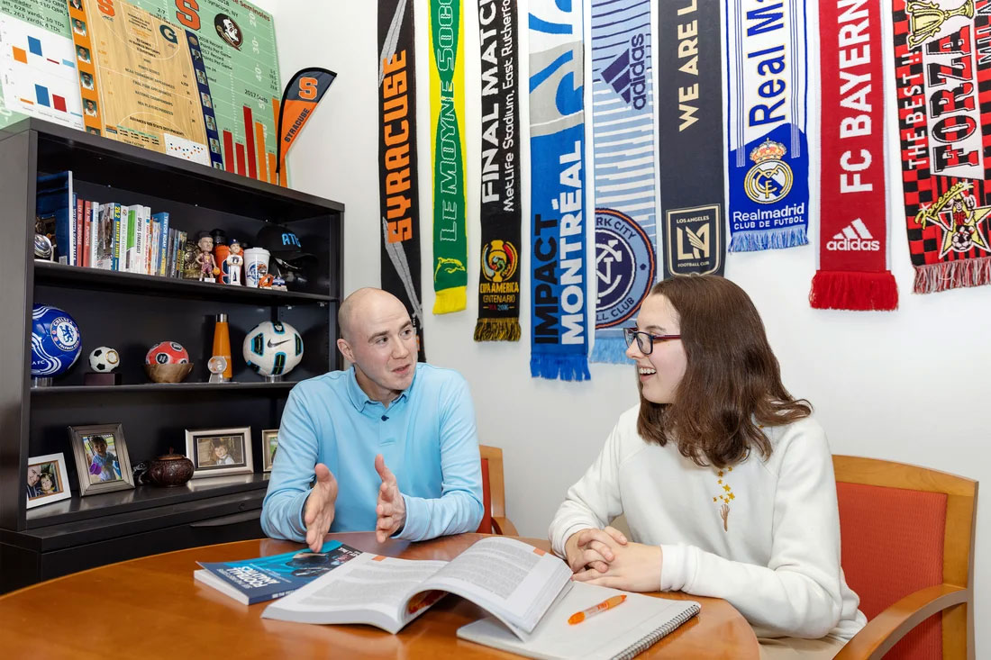 Alison Gilmore and Francesco Riverso talk in an office.