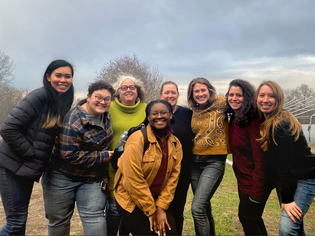 A group of people are posed outside