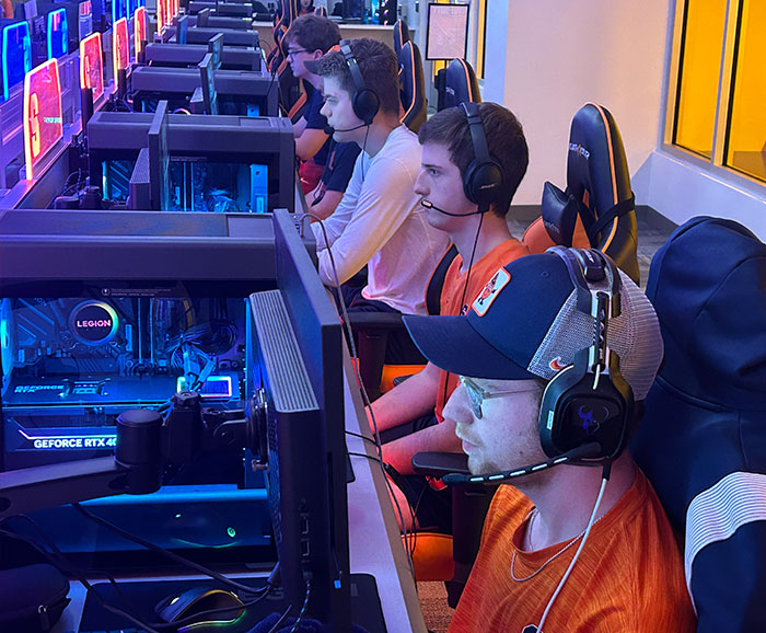 students sitting at computer consoles playing esports games