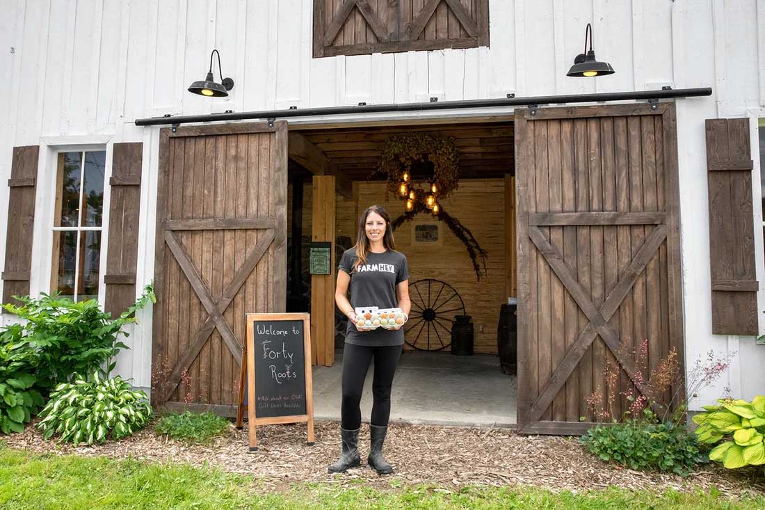 Chaya Charles stands in front of barn