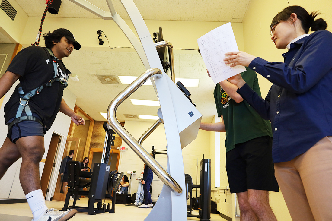 professor valuating student on a treadmill