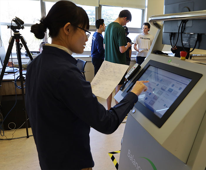 young professor standing at terminal entering information