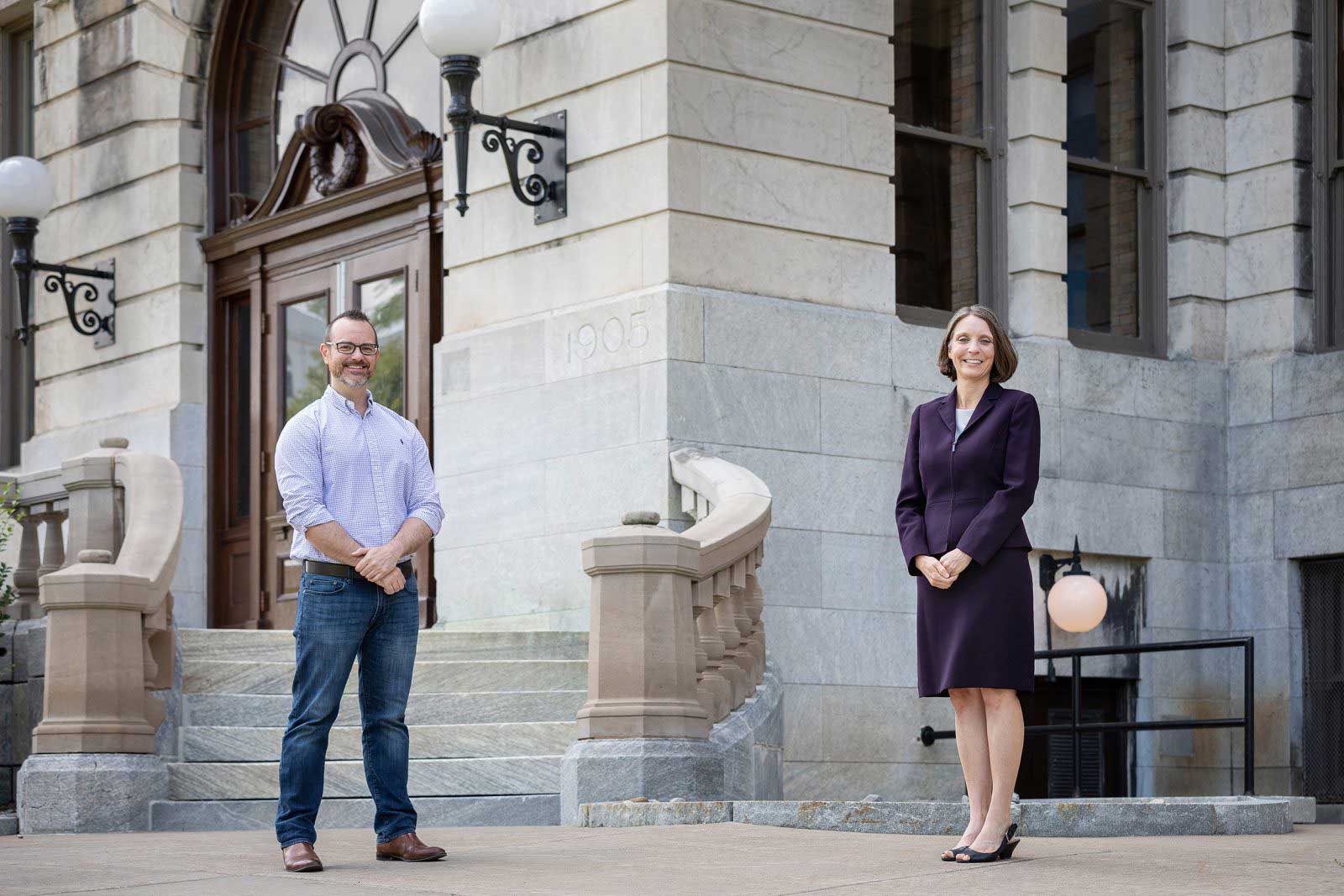 two professors stand in front of the Hall of Languages