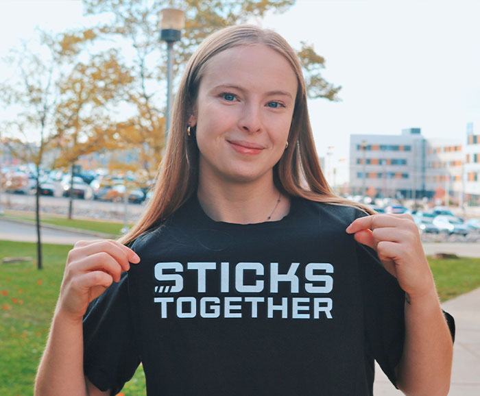 Sarah Thompson points to her shirt which shows the Sticks Together logo