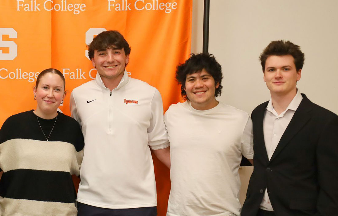 one female and 3 male students standing together at awards ceremony