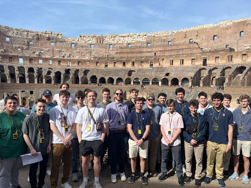 students stand in front of the Colosseum