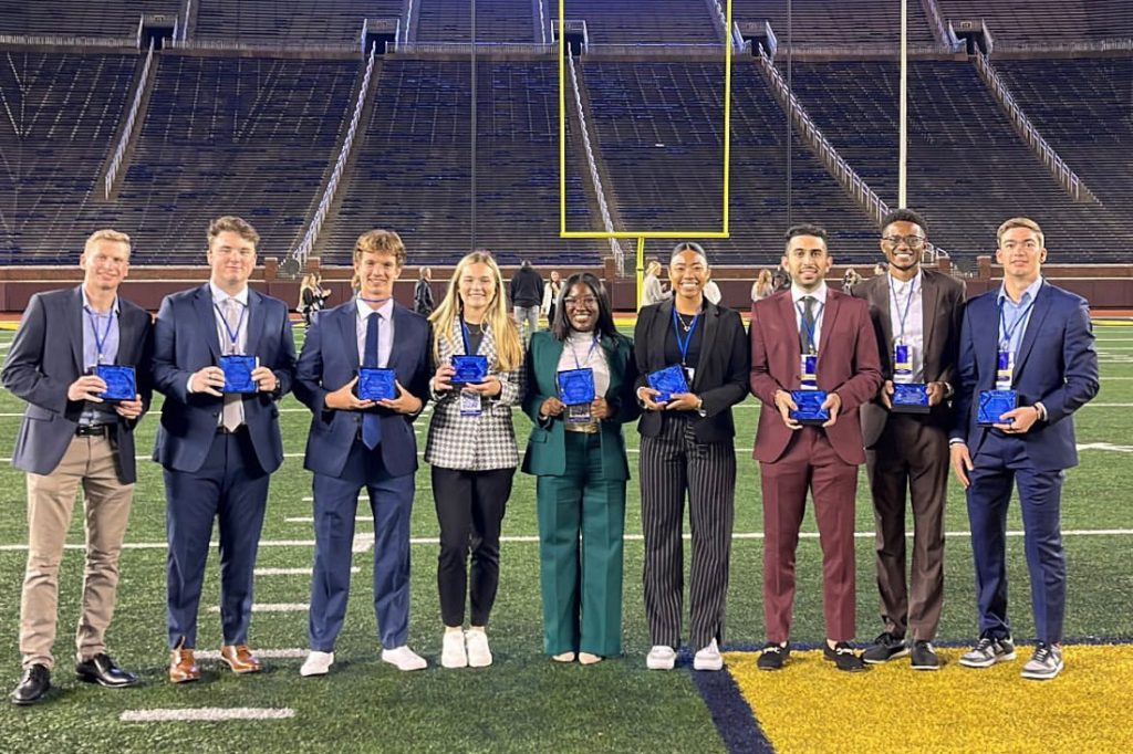 9 individuals posing with awards