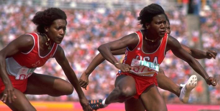 Three women jumping hurdle at olympics