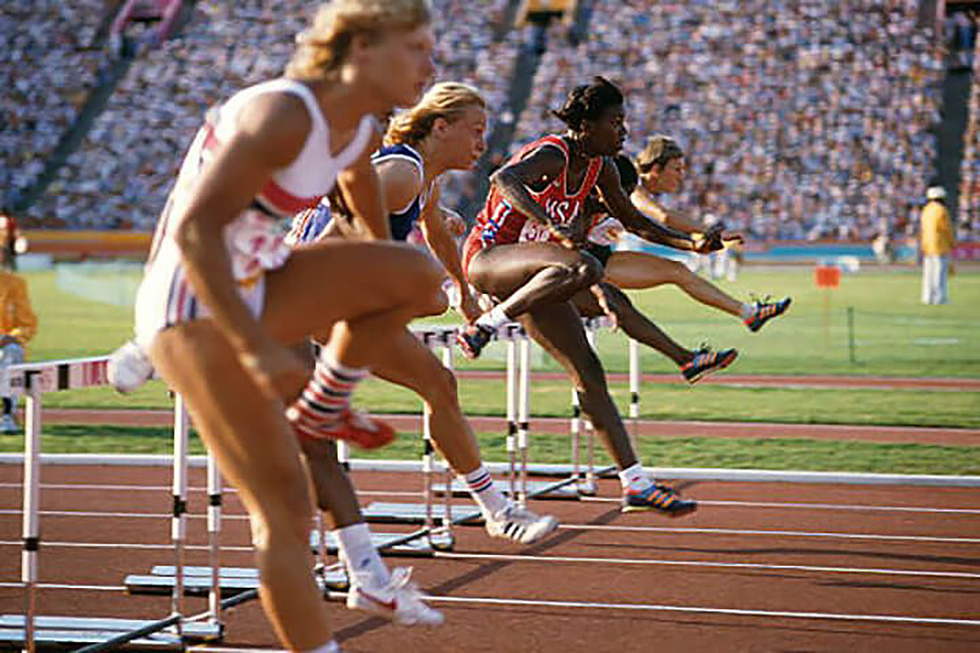 Four women jumping hurdles at 1984 summer olympics